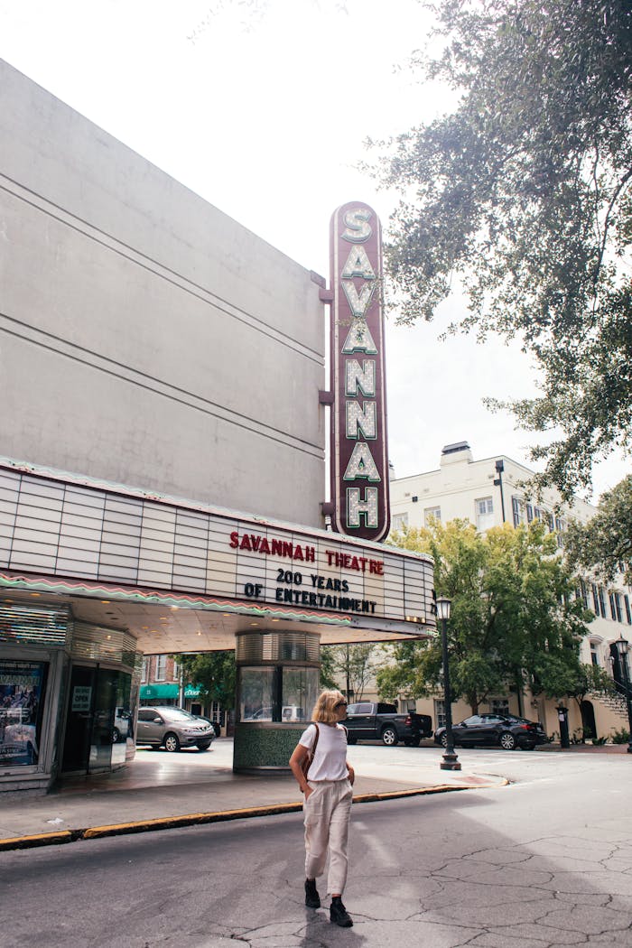 Person walking past the iconic Savannah Theatre, a landmark in Georgia, USA.